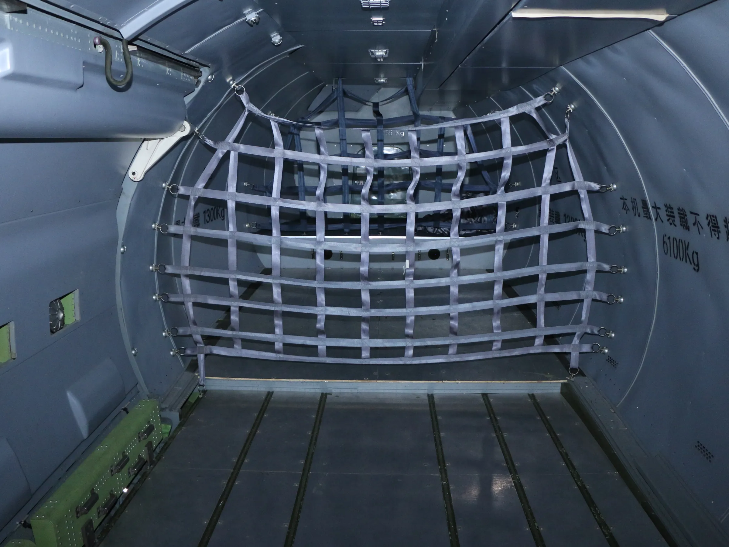 MA60 freighter main-deck cargo bay, restraint net rigged, looking aft